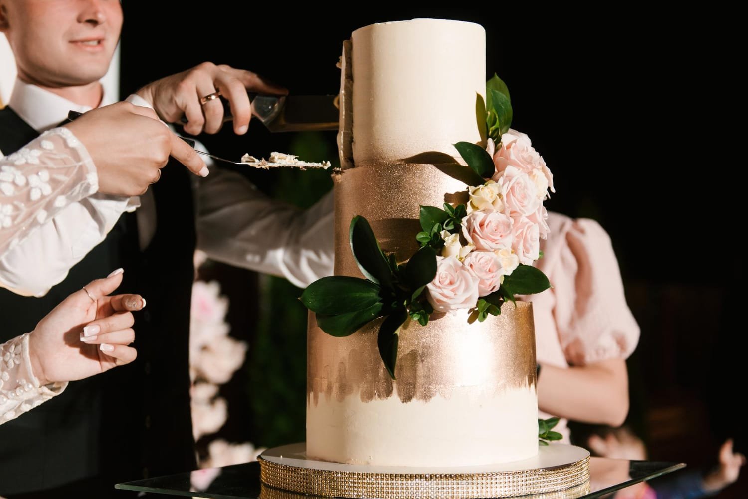 Rustic naked wedding cake decorated with fresh berries, strawberries, and powdered sugar.