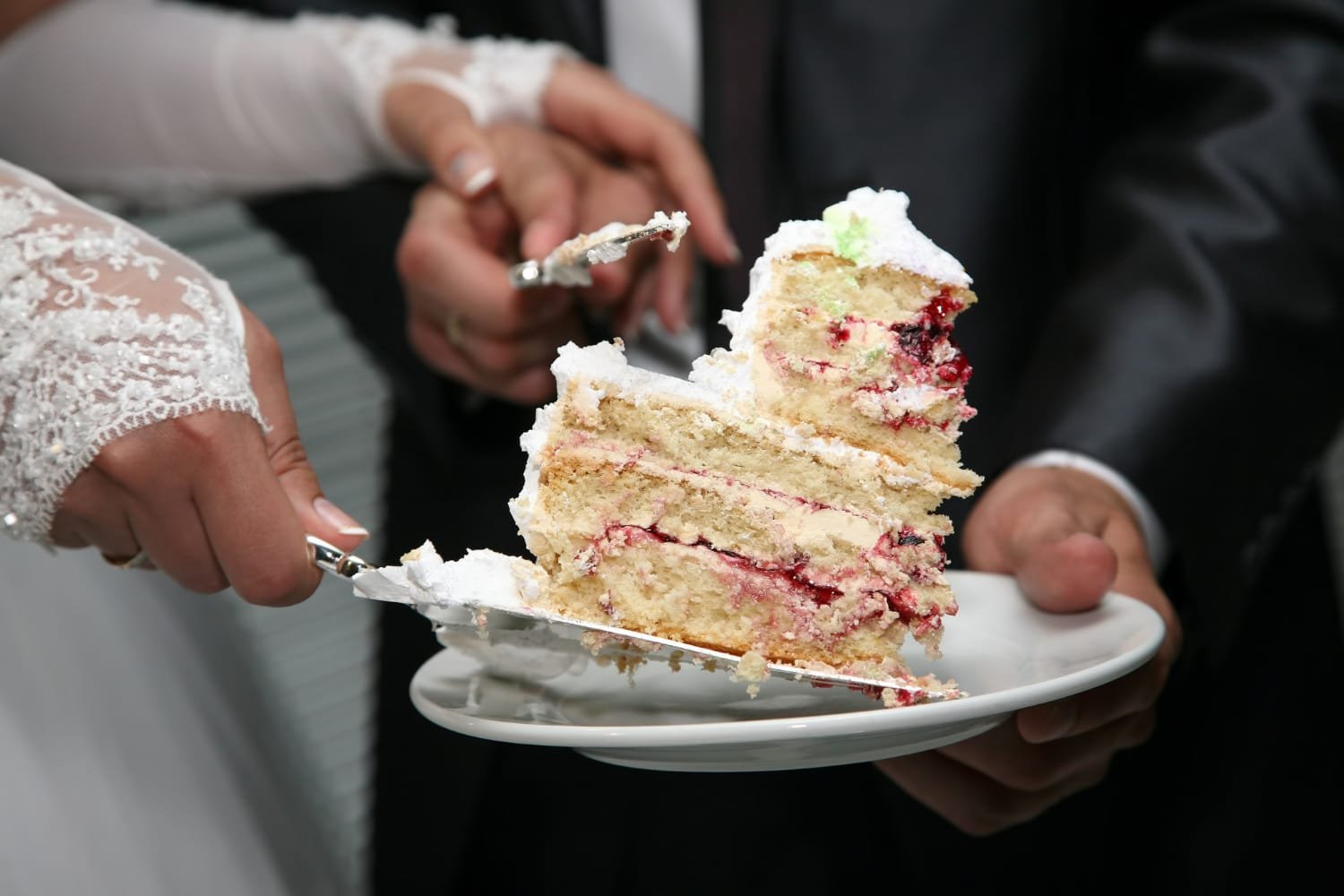 Bride and groom cutting the wedding cake together at their outdoor wedding reception.