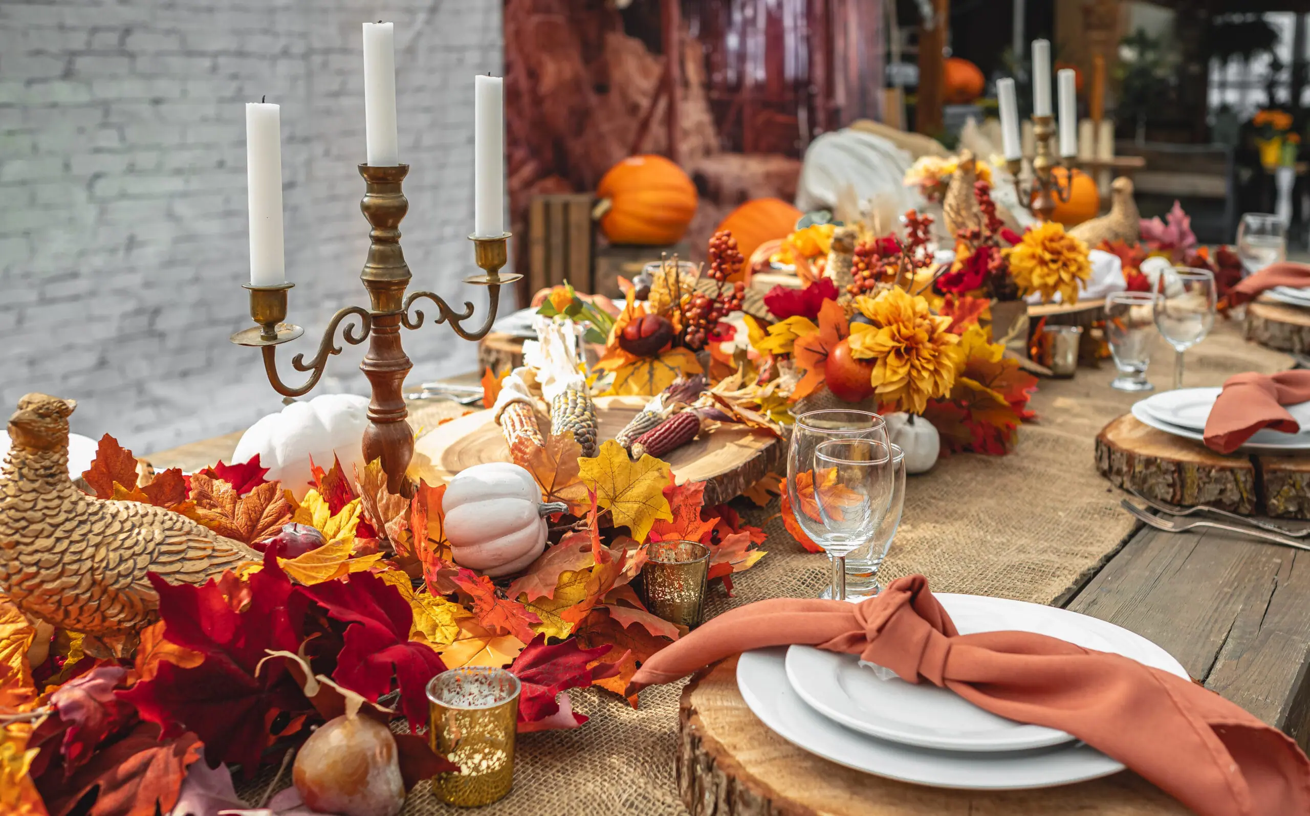 Autumn wedding table setting decorated with pumpkins and fall leaves for a seasonal reception