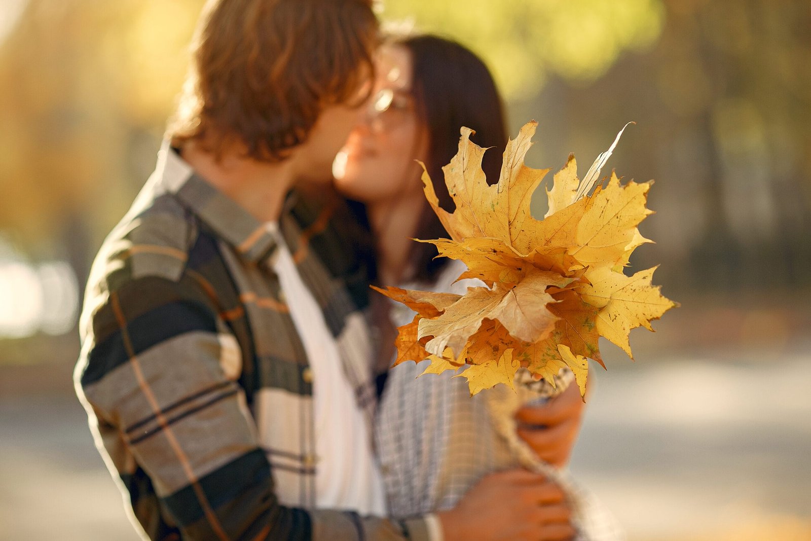 November Wedding Checklist: What to Confirm 30 Days Before the Wedding 6 Couple embracing with golden autumn maple leaves during the final month of wedding planning. November Wedding Checklist