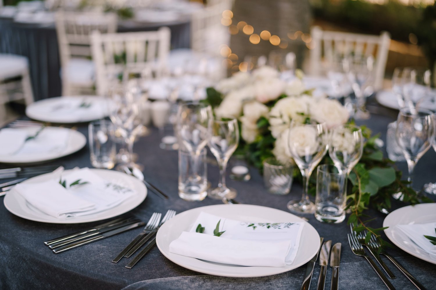 Wedding Linen Rental: Hidden Costs and Fees the Quote May Not Show 19 Wedding table setting decorated with fresh flowers in a brass vase.