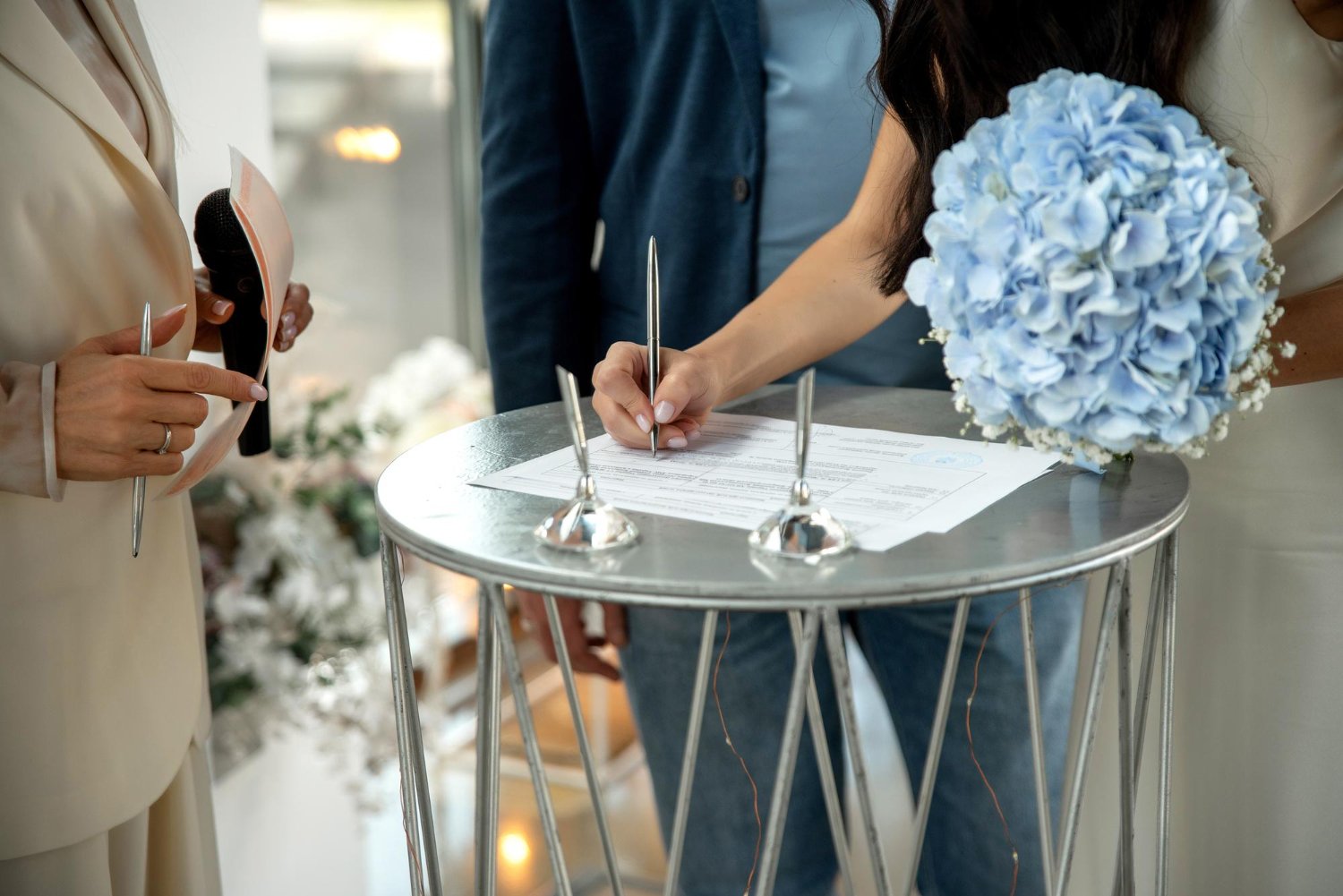 The Complete Guide to Wedding Witnesses 28 Couple signing their marriage license with a witness looking on