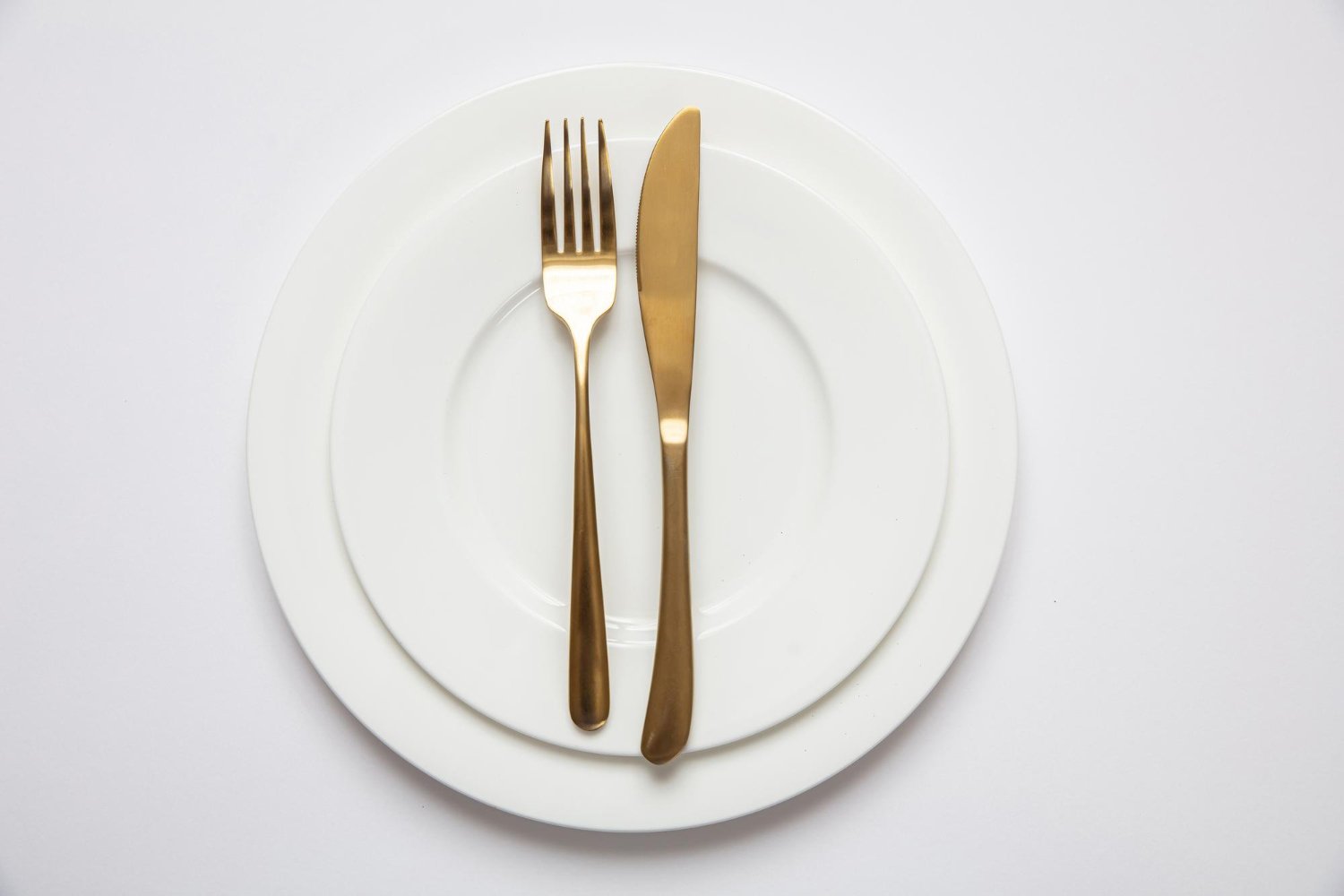 Wedding Registry Hidden Fees: What Nobody Mentions Until It Happens 14 Elegant formal table setting with gold cutlery on a white china plate