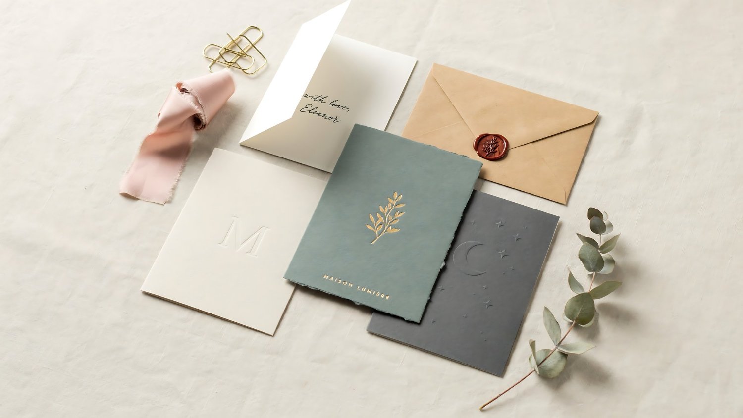 Wedding Invitation Timing and Wording: When to Send, What to Say, and What to Leave Off 13 Elegant wedding stationery suite with a wax seal and eucalyptus sprigs showing a coordinated invitation set