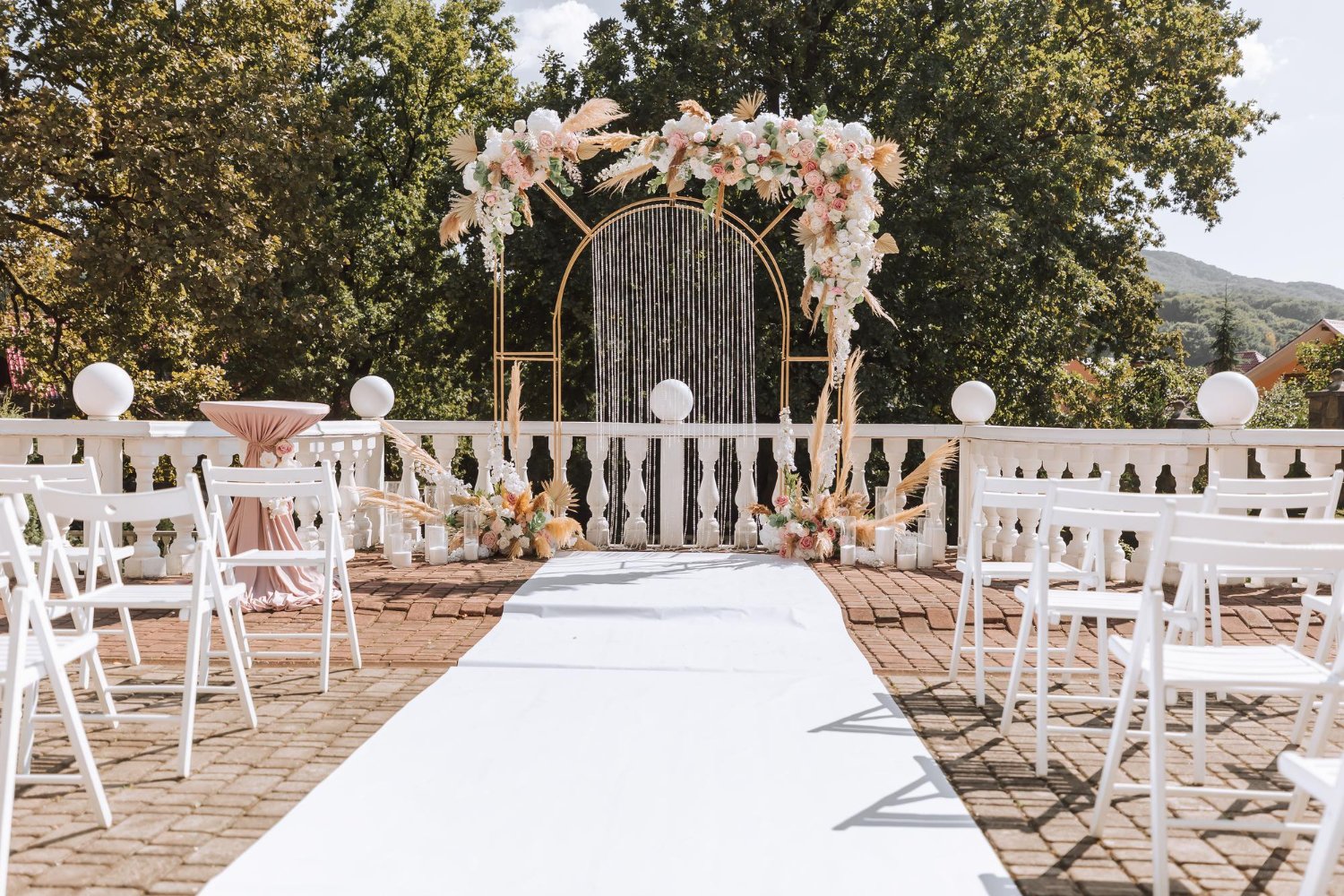 Elegant wedding aisle with a white runner leading to a flower-covered arch, an example of a clear, level accessible route