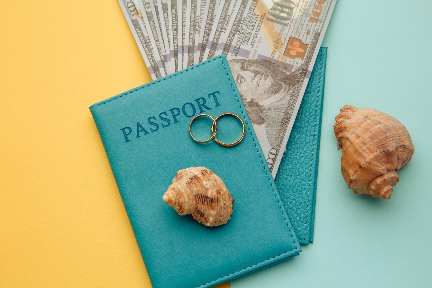 Honeymoon Travel Insurance Coverage: What Each Type of Policy Actually Pays For 14 Passports, wedding rings, cash, and seashells arranged together symbolizing honeymoon travel costs and insurance