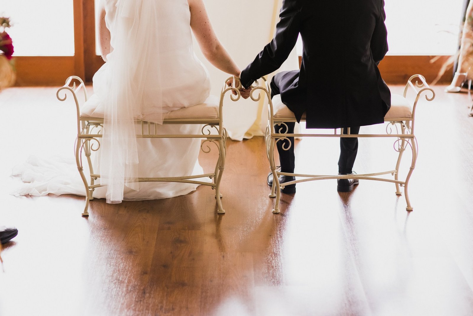 Wedding guests holding hands while seated during an accessible wedding ceremony
