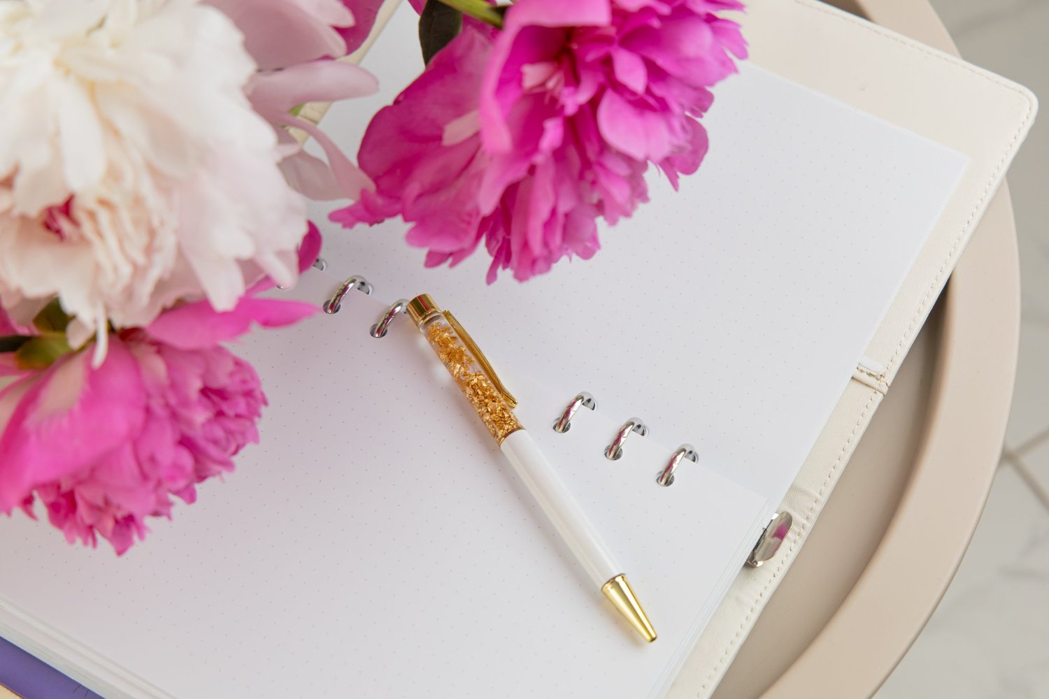 Name Change After Marriage: Costs, Deadlines, and the Paperwork Nobody Explains 13 Pink peonies and a gold pen on a blank wedding planning checklist page