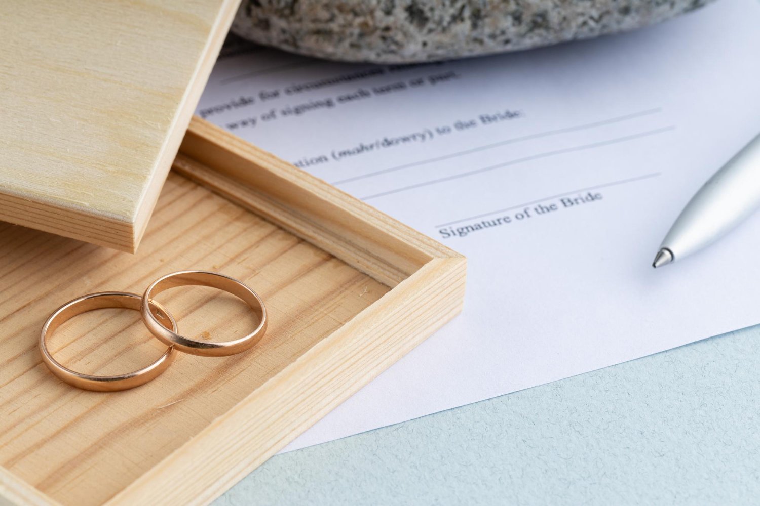 Name Change After Marriage: Costs, Deadlines, and the Paperwork Nobody Explains 11 Wedding rings in a wooden box beside a marriage contract form ready for signature