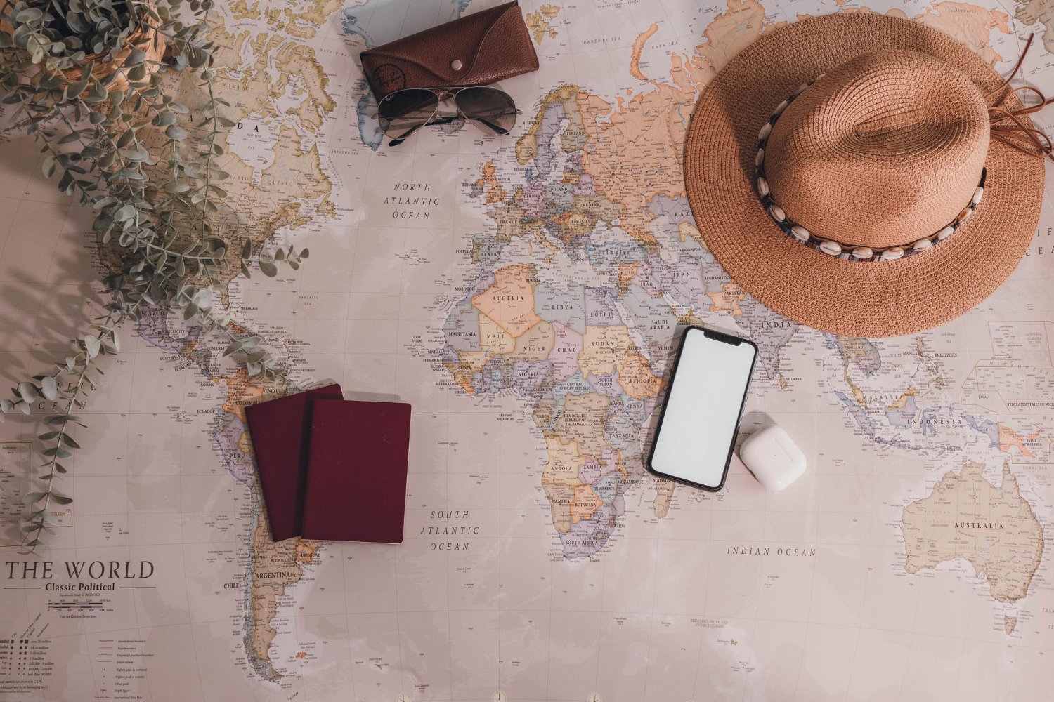 Honeymoon Travel Insurance Coverage: What Each Type of Policy Actually Pays For 13 World map with passport, hat, and sunglasses in an elegant travel planning flat lay