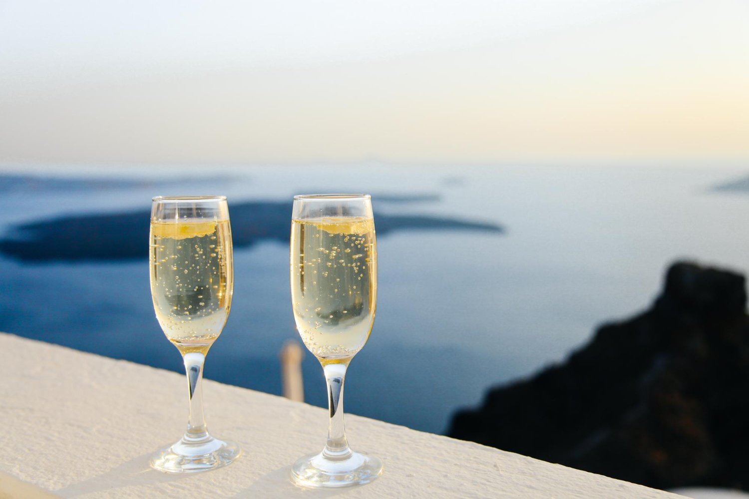 Destination Wedding Guest Costs: What to Really Expect (and How to Budget) 6 Champagne glasses overlooking ocean view at a destination wedding resort