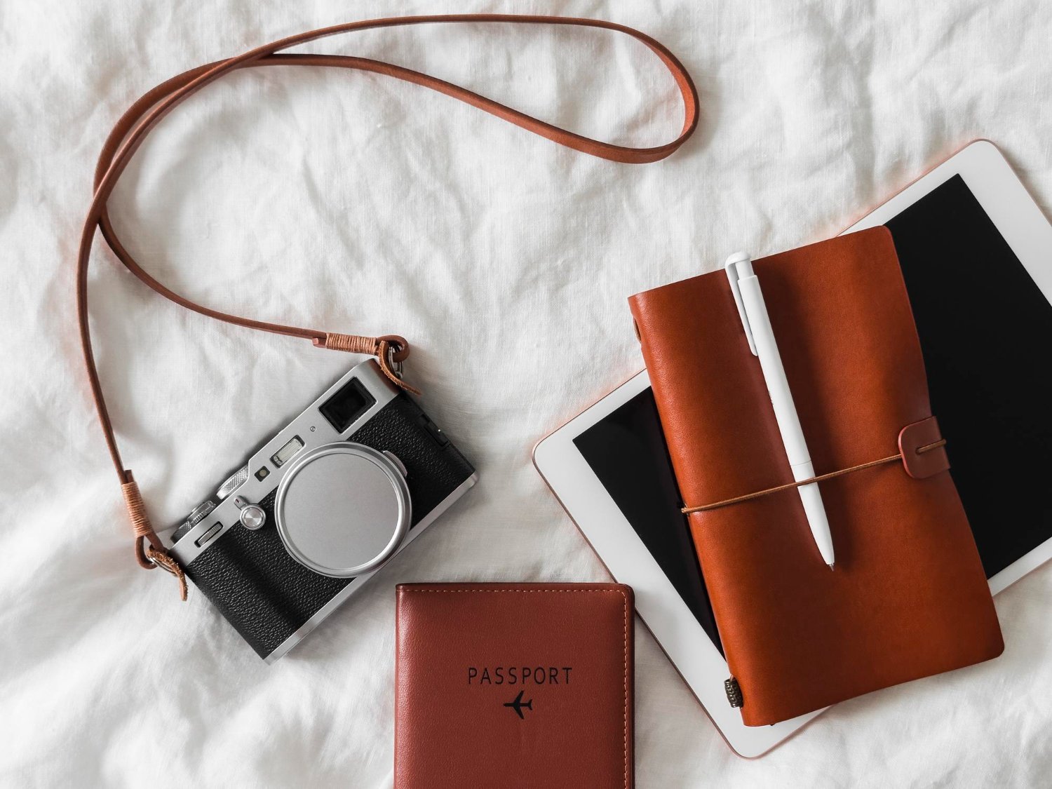 Destination Wedding Guest Costs: What to Really Expect (and How to Budget) 9 Aesthetic travel flatlay with camera, passport, and notepad for destination wedding planning