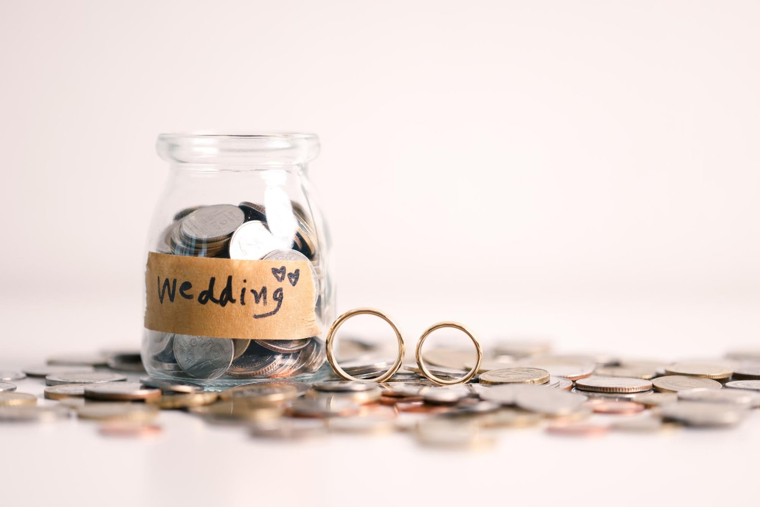 Wedding Officiant Cost: Hidden Fees and Questions to Ask Before You Book 10 Glass jar labeled Wedding filled with coins and gold rings, symbolizing wedding budget savings