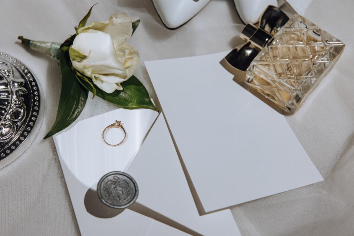 Elegant wedding invitation flatlay with engagement ring, bridal shoes, and perfume